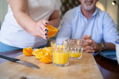 Free A person preparing fresh orange juice on a chopping board indoors, showcasing healthy lifestyle. Stock Photo