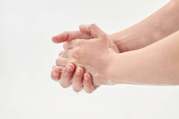 Khái niệm coronavirus hoặc Covid-19. Một cô gái nhỏ rửa tay bằng xà phòng. Quy trình rửa tay bằng xà phòng trên nền trắng. Cận cảnh, lấy nét chọn lọc bức ảnh sẵn có