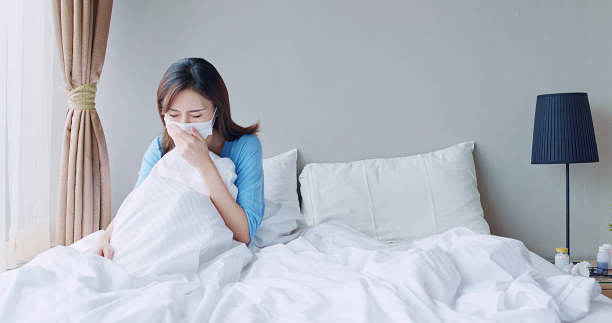 người phụ nữ châu Á ho trong phòng ngủ